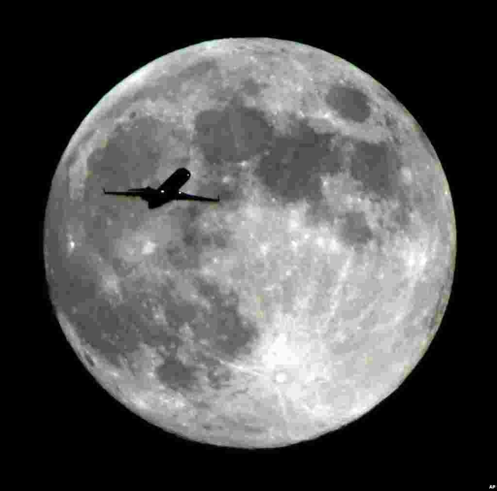 An airliner approaching Los Angeles International Airport crosses the Harvest Moon as seen from Monterey Park, California, USA, Sept 18, 2013. 