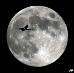 Sebuah pesawat yang bersiap mendarat di Bandara Internasional Los Angeles melintas di depan Bulan menjelang musim gugur di Belahan Bumi Utara, 18 September 2018. (Foto: Nick Ut/AP Photo)