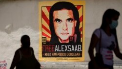 Una mujer camina cerca de un cartel pidiendo la libertad del empresario colombiano y enviado especial venezolano Alex Saab, en Caracas, Venezuela, el16 de octubre de 2021.