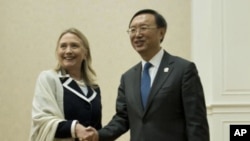 U.S. Secretary of State Hillary Rodham Clinton, left, and Chinese Foreign Minister Yang Jiechi pose for photos before their meeting on the sideline of the ASEAN regional forum in Phnom Penh, July 12, 2012.