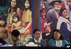 FILE - Silvia Flores, right, testifies while Celestina Flores, center, and her husband listen, during a public hearing of Peru's Truth and Reconciliation Commission in Lima, Sept. 10, 2002. The commission was hearing testimony from witnesses of atrocities committed by both sides in the 1980s and 1990s during the government's battle with Shining Path insurgents..