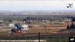 Image made from militant video posted online by the Aamaq News Agency, a media arm of the Islamic State group, Jan. 9, 2017, purports to show the moment of a Turkish missile strike, in the northern Syrian town of al-Bab, in Aleppo province, Syria. 