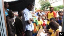 Des électeurs présentent leurs papiers d'identité, à Maputo, Mozambique, le 15 octobre 2014. 