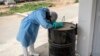 A hygienist rests as he waits outside a decontamination area in a COVID-19 coronavirus treatment center that cares for positive patients who show little or no symptoms, in Dakar, Senegal.