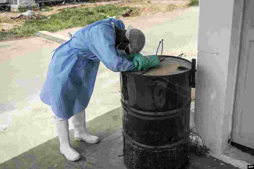 A hygienist rests as he waits outside a decontamination area in a COVID-19 treatment center that cares for positive patients who show little or no sign of disease, in Dakar, Senegal.