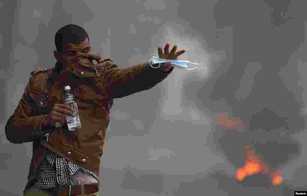 A supporter of the Muslim Brotherhood and ousted President Mohamed Morsi shouts slogans in front of tear gas fired by riot police and army during clashes near Giza square, south of Cairo, Nov. 29, 2013.