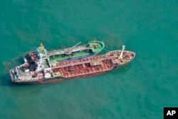 This May 24, 2018, photo released by Japan's Ministry of Defense shows the North Korean-flagged tanker Sam Jong 2, bottom, alongside the Myong Ryu 1, a vessel of unknown nationality, in the East China Sea. Japan's Foreign Ministry says a Japanese navy surveillance aircraft spotted a suspected unidentified ship apparently transferring fuel to a North Korean tanker in the open seas.