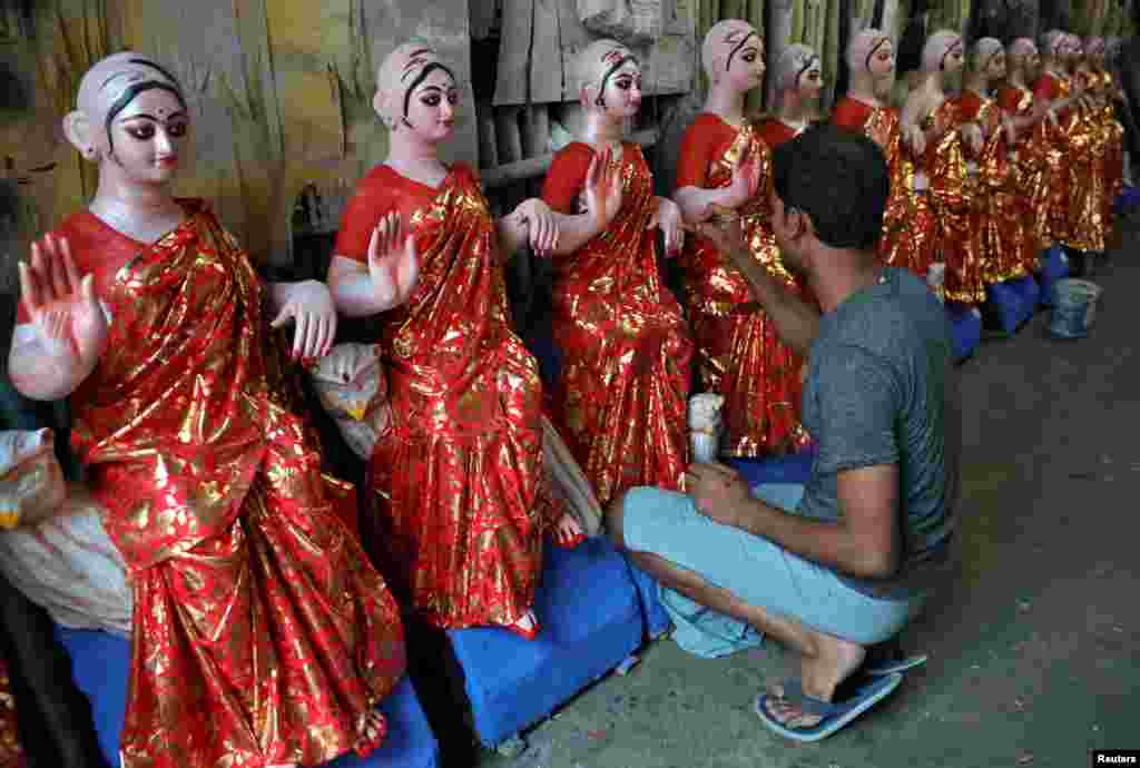 An artist paints idols of Hindu goddess of wealth, Laxmi, at his workshop, ahead of the Laxmi Puja festival in Kolkata, India.