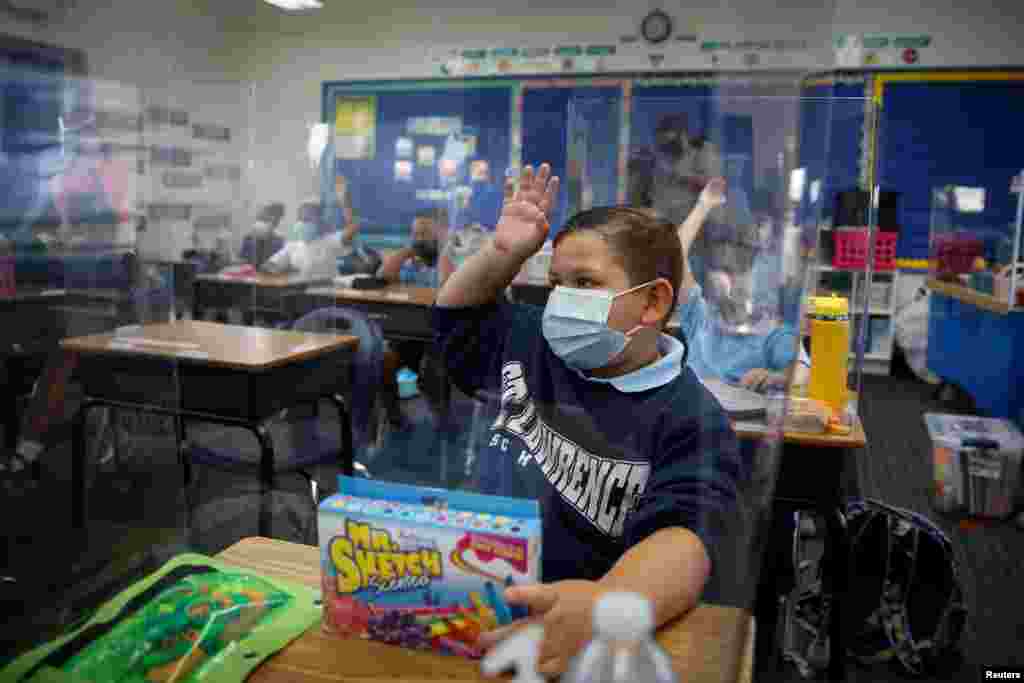 A student wearing a protective mask, attends class on the first day of school, amid the COVID-19 pandemic, at St. Lawrence Catholic School in North Miami Beach, Florida.