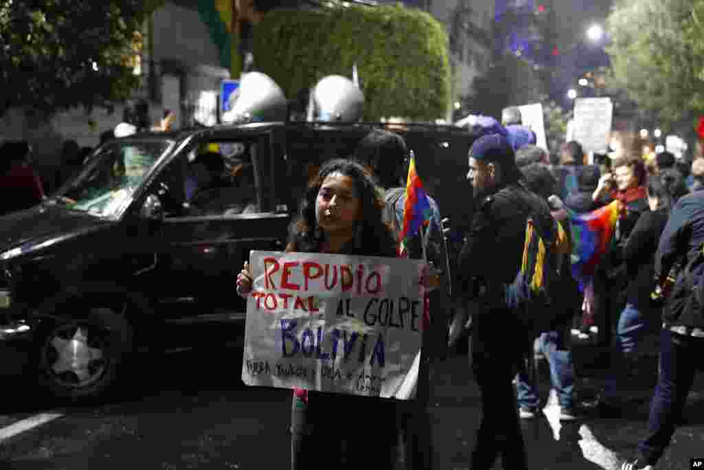 Una mujer sostiene un letrero que dice en español: &quot;Repudio total al golpe en Bolivia. Fuera Yanquis y la OEA&quot;, mientras los bolivianos en México y los partidarios del expresidente Evo Morales protestaron frente a la embajada boliviana en la Ciudad de México, el lunes 11 de noviembre de 2019.