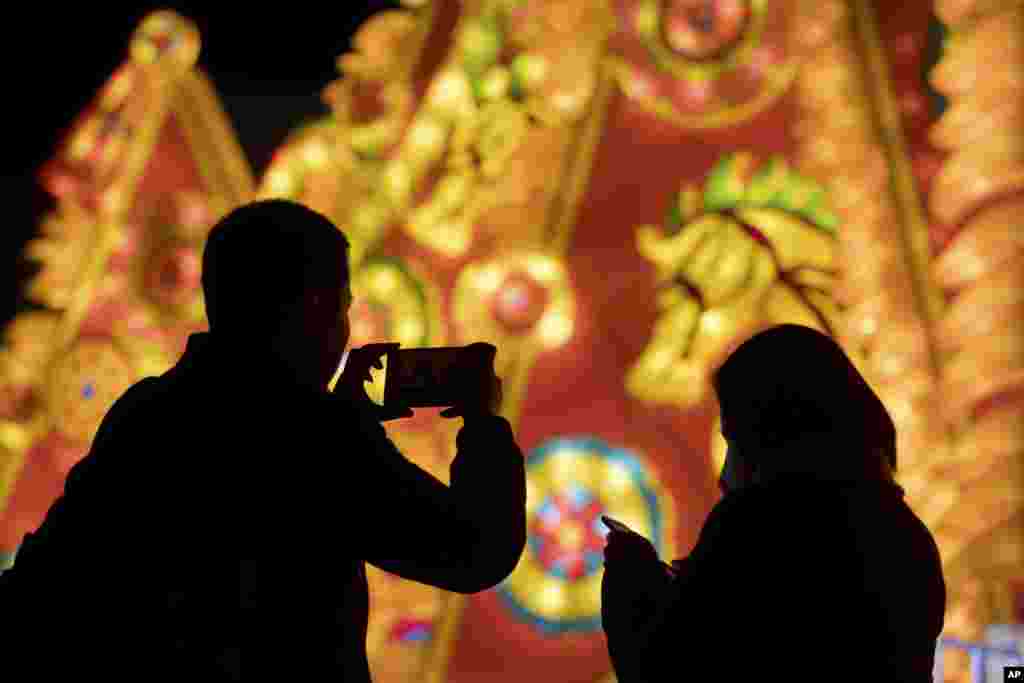 Seorang pria mengambil foto pada Festival Lentera di sebuah taman di Beijing, China.