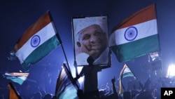 A supporter of veteran Indian social activist Anna Hazare holds his portrait on the ninth day of Hazare's fast at Ramlila grounds in New Delh,i Aug. 24, 2011.
