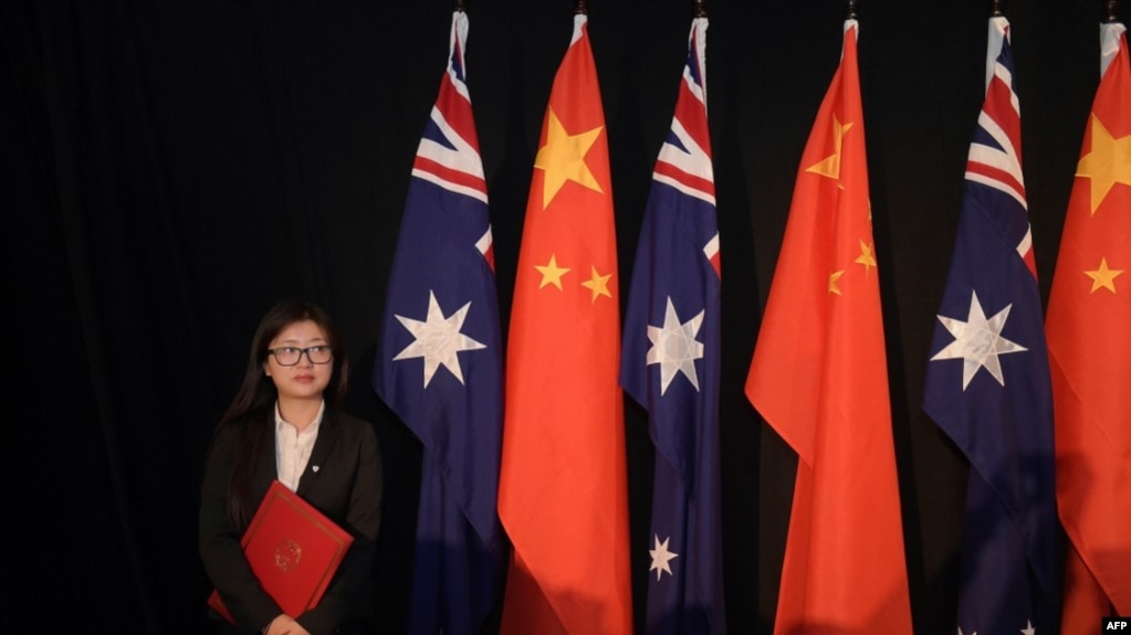 资料照：一名女子站在中澳国旗旁。（2015年6月17日）(photo:VOA)