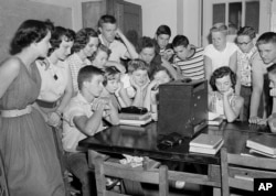 FILE - A group of students at the Russell High School in Atlanta, Ga., gather around a radio shortly after noon to hear news that segregation has been ruled out in public schools in a unanimous Supreme Court decision on May 17, 1954.
