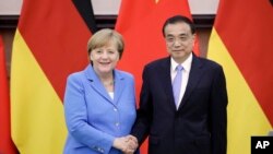 앙겔라 메르켈 독일 총리와 리커창 중국 총리가 24일 베이징 인민대회당에서 기자회견을 마친 후 악수하고 있다. 