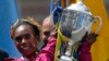 Rita Jeptoo of Kenya hoists the trophy after winning the women's division of the 118th Boston Marathon, April 21, 2014.