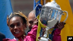 Rita Jeptoo of Kenya hoists the trophy after winning the women's division of the 118th Boston Marathon, April 21, 2014.