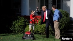 U.S. President Donald Trump welcomes Frank Giaccio, 11, as he cuts the Rose Garden grass at the White House in Washington, Sept. 15, 2017. 