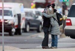 Dua perempuan berpelukan di pojokan Broadway dan Table Mesa Drive dekat supermarket King Soopers, lokasi penembakan massal, di Boulder, Colorado, Senin, 22 Maret 2021. (Foto: Joe Mahoney/AP)