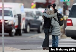 Dua perempuan berpelukan di pojokan Broadway dan Table Mesa Drive dekat supermarket King Soopers, lokasi penembakan massal, di Boulder, Colorado, Senin, 22 Maret 2021. (Foto: Joe Mahoney/AP)