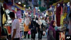 Para pengunjung Bazaar Ramadan di Kuala Lumpur, Malaysia, mengenakan masker saat berbelanja makanan untuk berbuka puasa di tengah pandemi COVID-19, 19 April 2021. (AP Photo/Vincent Thian)