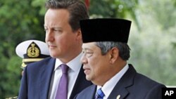 အင်ဒိုနီးရှား သမ္မတ ဆူစီလို ဘန်ဘမ် ယိုဒိုယိုနို (ညာ) Susilo Bambang Yudhoyono (R)မှ ဗြိတိန်ဝန်ကြီးချုပ် ဒေးဗစ် ကင်မရွန်း (ဘယ်) David Cameron အား မာဒေးကား (Merdeka) (လွတ်လပ်ရေး) နန်းတော်၊ ဂျာကာတာ သို့ ကြိုဆိုစဉ်၊ ဧပြီ ၁၁၊ ၂၀၁၂ 