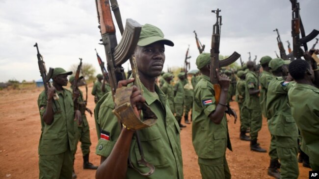 FILE - South Sudanese rebel soldiers raise their weapons at a military camp in the capital Juba, South Sudan.