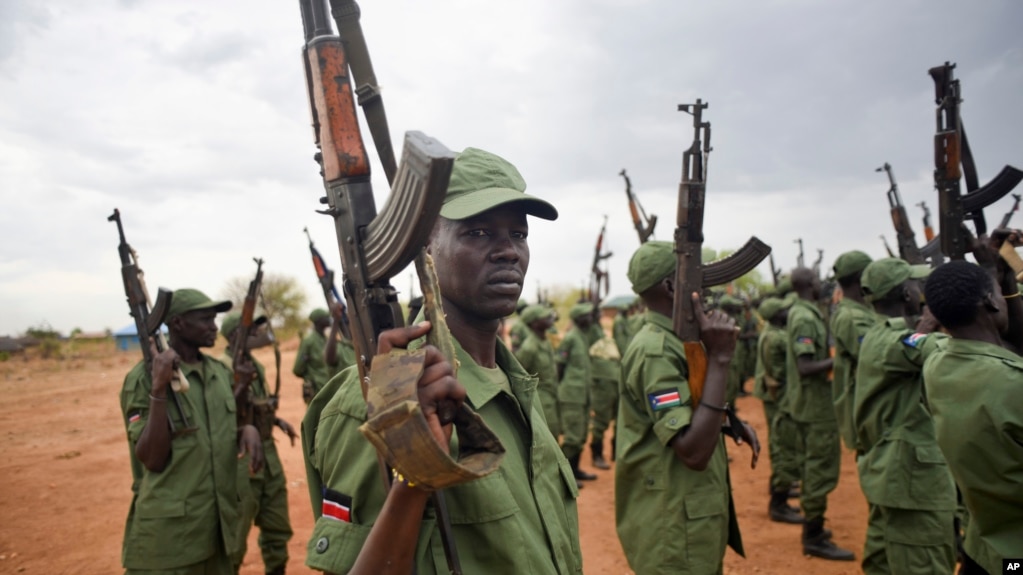 FILE - South Sudanese rebel soldiers raise their weapons at a military camp in the capital Juba, April 7, 2016.