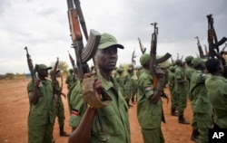 FILE - South Sudanese rebel soldiers raise their weapons at a military camp in the capital Juba, South Sudan.