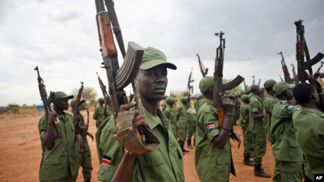 FILE - South Sudanese rebel soldiers raise their weapons at a military camp in the capital, Juba, April 7, 2016.