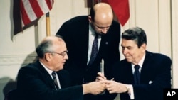 FILE - U.S. President Ronald Reagan (R) and Soviet leader Mikhail Gorbachev exchange pens during the Intermediate Range Nuclear Forces Treaty signing ceremony in the White House East Room in Washington, D.C., Dec. 8, 1987. 