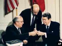 FILE - U.S. President Ronald Reagan (R) and Soviet leader Mikhail Gorbachev exchange pens during the Intermediate Range Nuclear Forces Treaty signing ceremony in the White House East Room in Washington, D.C., Dec. 8, 1987.