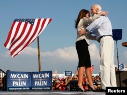 US Republican presidential candidate Senator John McCain (R-AZ) and his running mate Alaska Governor Sarah Palin hug during a campaign stop in O'Fallon, Missouri August 31, 2008.