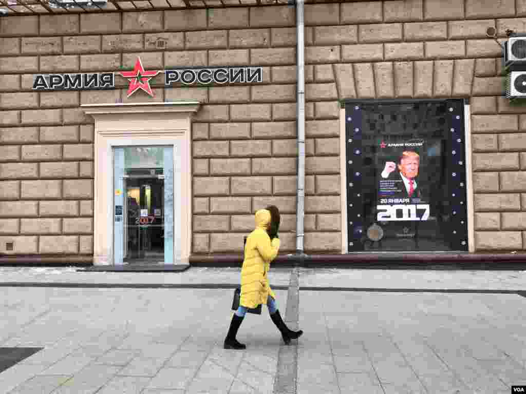 A woman walks by a Russian Army store displaying a poster of Donald Trump across from the U.S. embassy in Moscow, Jan. 20, 2016. (D. Schearf/VOA) 