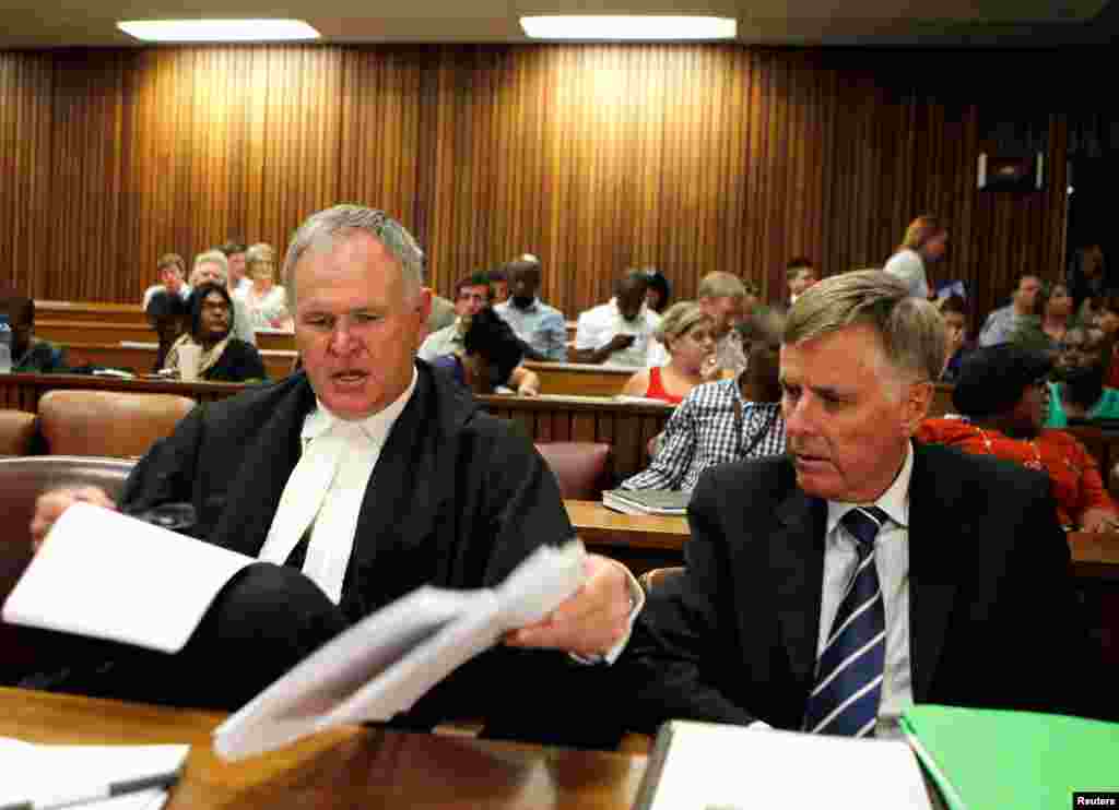 Oscar Pistorius's lawyers Barry Roux (L) and Brian Webber prepare documents before the start of the application to appeal some of his bail conditions at a Pretoria court, March 28, 2013.