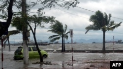 A taxi negoiates a flooded coastal road at Ha Long city, in the north-eastern coastal province of Quang Ninh, after the passage of the typhoon Haiyan, Nov. 11, 2013. 