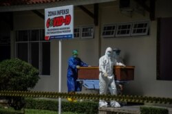 Para petugas kesehatan mendorong peti jenazah pasien COVID-19 di sebuah rumah sakit di Bandung, Jawa Barat, 17 Juni 2021. (Foto: Antara Foto/Raisan Al Farisi/ via Reuters)