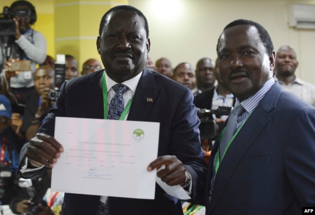 Kenya's National Super Alliance and opposition leader Raila Odinga (L) and running mate Kalonzo Musyoka show their clearance certificate, May 28, 2017 in Nairobi, after Odinga has presented his candidacy for the presidential race.