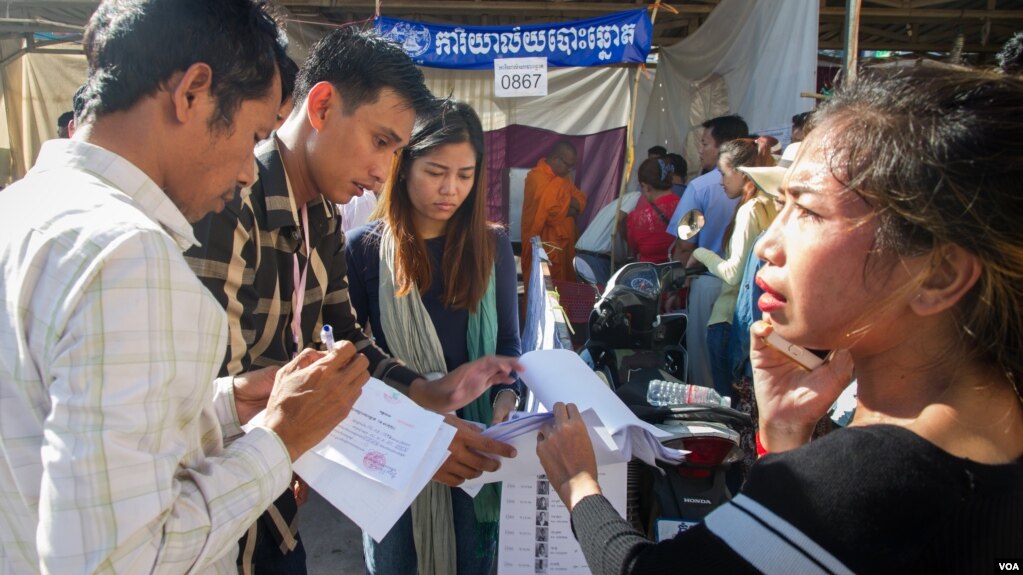 Voters check the voters' list during the local elections at a polling station in Stung Meanchey commune, Meanchey district, Phnom Penh, June 4, 2017. More than 7 million Cambodians are thought to have voted in Sunday’s poll, about 90 percent of the almost 8 million who registered. (Neou Vannarin/VOA Khmer)