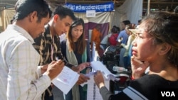 Voters check the voters' list during the local elections at a polling station in Stung Meanchey commune, Meanchey district, Phnom Penh, June 4, 2017. More than 7 million Cambodians are thought to have voted in Sunday’s poll, about 90 percent of the almost 8 million who registered. (Neou Vannarin/VOA Khmer)