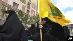A female demonstrator holds a flag of the Lebanese militant group Hezbollah during a sit-in protest against the Saudi, Bahraini and Yemeni leaders' crackdown on their opposition in Tehran, Iran, April 22, 2011 (file photo).