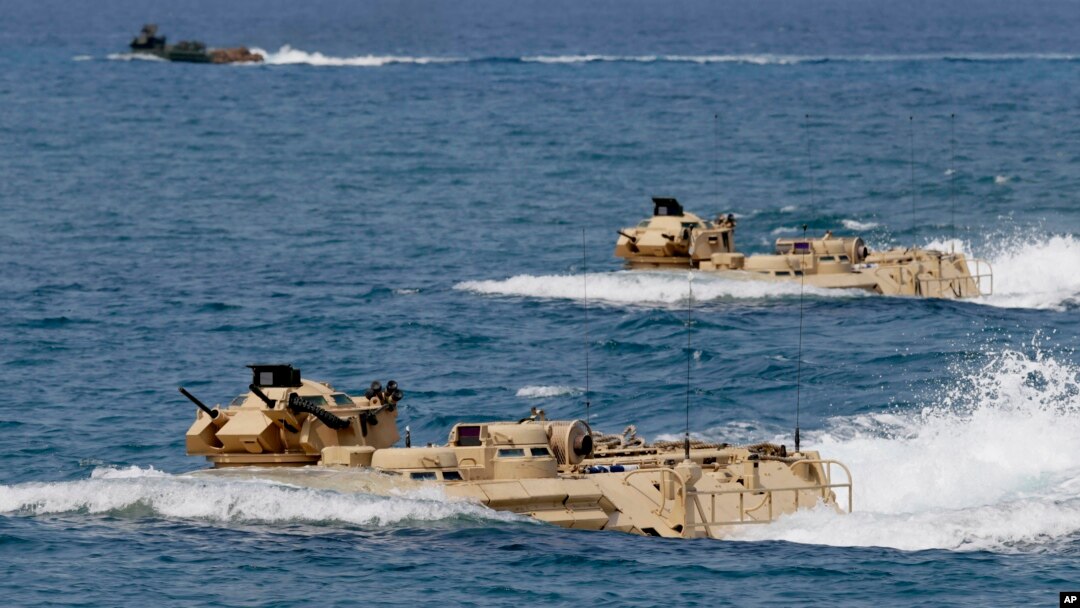 FILE - U.S. Navy amphibious assault vehicles with Philippine and U.S. troops on board are seen during joint exercises near a beach facing one of the contested islands in the South China Sea known as the Scarborough Shoal, April 21, 2015.