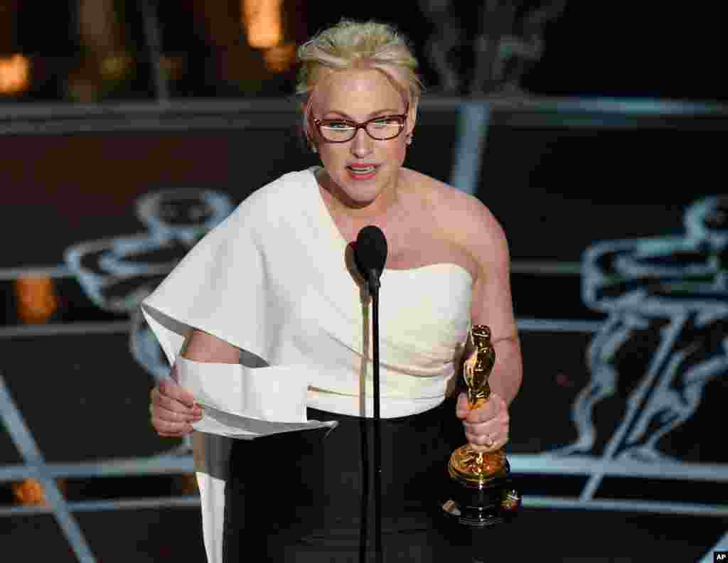 Aktris Patricia Arquette menerima piala Oscar untuk aktris pembantu terbaik dalam film &quot;Boyhood&quot; (22/2). (AP/Invision/John Shearer)