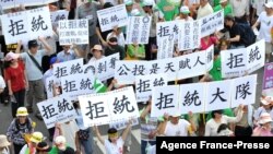 FILE - Supporters of Taiwan's Democratic Progressive Party hold placards reading "refuse reunification" during a protest in Taipei, June 26, 2010, against a trade deal that was to be struck soon with China. The idea of reunification has been losing popularity for years in Taiwan.