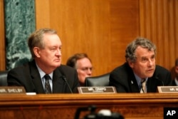 FILE - Senate Banking Committee Chairman Senator Mike Crapo, R-Idaho, left, and the committee's ranking member Senator Sherrod Brown, D-Ohio, listen on Capitol Hill in Washington, July 13, 2017.