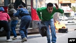 An Egyptian civilian runs out of a public bus after it was caught up in clashes between supporters of Egypt's deposed president Mohamed Morsi and police in the northeastern part of Cairo's Nasr City district, Jan. 3, 2014.