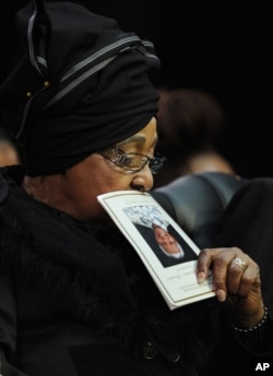 Winnie Madikizela-Mandela, Nelson Mandela's former wife, holds up the service program while attending former South African President Nelson Mandela's funeral service in Qunu, South Africa, Dec. 15, 2013.