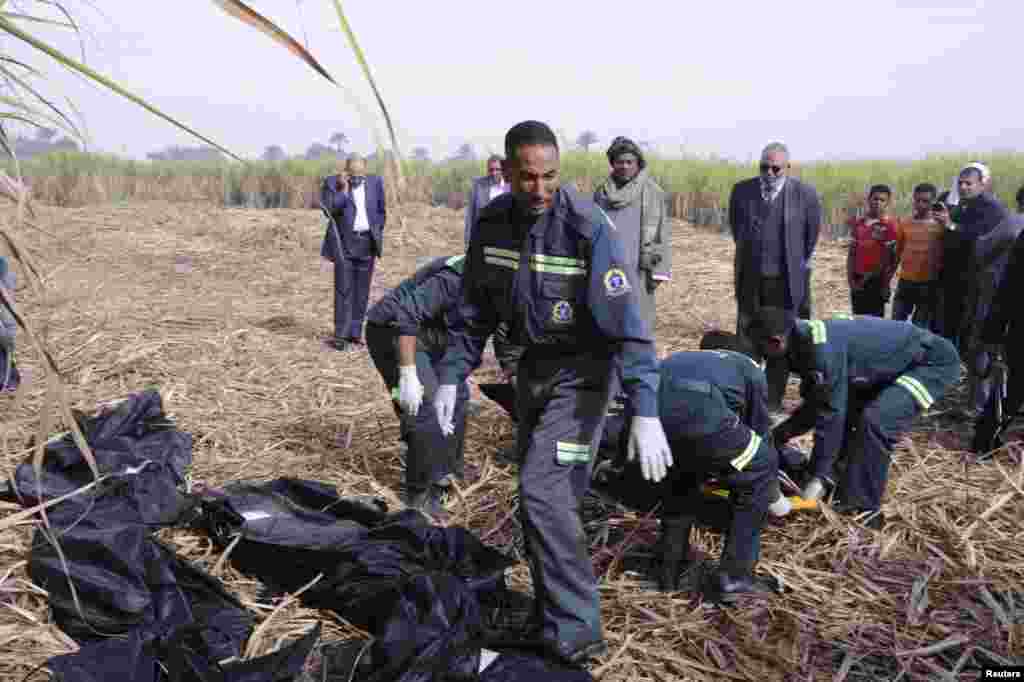 Police and rescue officials lift the bodies of tourists who died after a hot air balloon crashed in Luxor, Egypt, Feb. 26, 2013. 