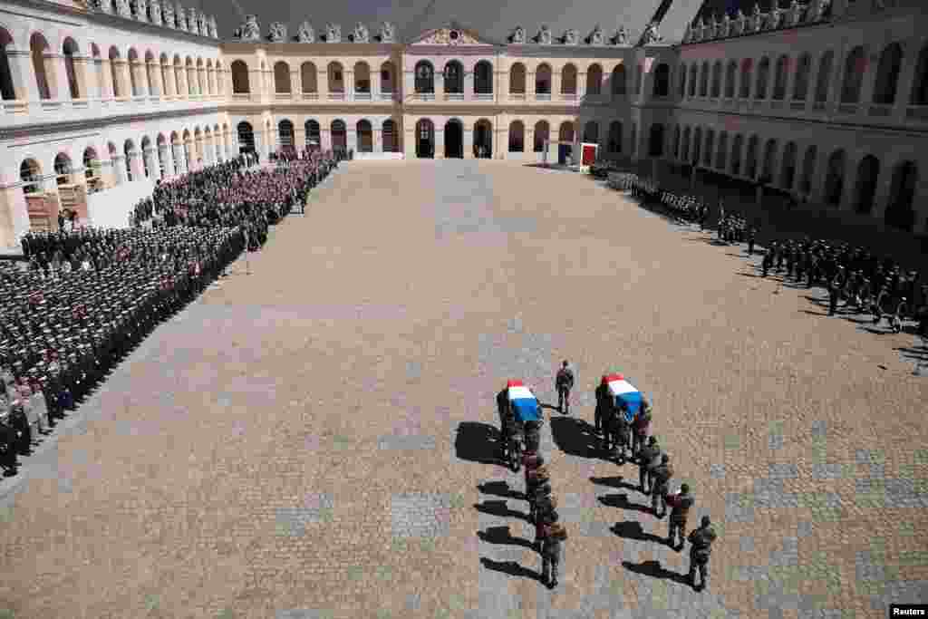 French soldiers of the Commando Hubert carry flag-covered coffins during a national ceremony at the National Invalides Hotel in Paris, of two French marine soldiers. Cedric de Pierrepont and Alain Bertoncello, died during a hostage-rescue operation in Burkina Faso.