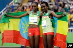 Ethiopia's gold medal winner Almaz Ayana, left, and Ethiopia's bronze medal winner Tirunesh Dibaba celebrate after the women's 10,000-meter final during the Summer Olympics in Rio de Janeiro, Brazil, Aug. 12, 2016.